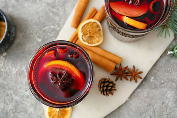 Glasses of tasty mulled wine on grunge background