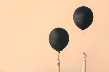 Foto op Canvas Vrouwelijke handen met zwarte luchtballonnen op gekleurde achtergrond © Pixel-Shot