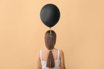 Woman with black air balloon on color background, back view
