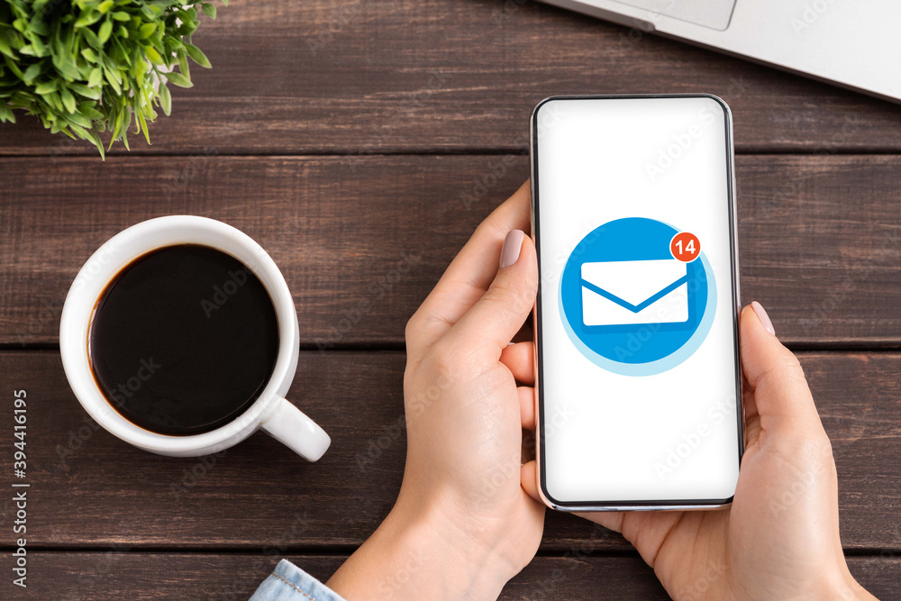 Poster Flat lay of woman holding smartphone with email envelope on screen, using mobile app to manage incoming mail messages