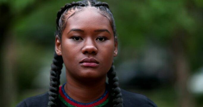Determined confident young black woman looking at camera raising fist