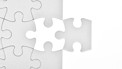 White jigsaw puzzle pattern background. placing last piece of jigsaw puzzle