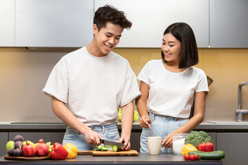 Chinese Husband And Wife Cooking Vegetable Salad In Modern Kitchen