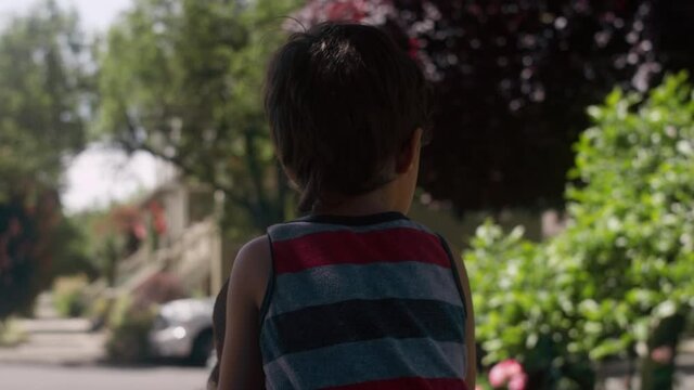 A young boy sitting on his mom's shoulders from behind