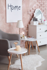 Stylish interior of living room with armchair and chest of drawers