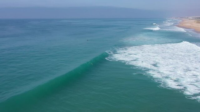 Drone view of surfer doing a duck dive under a big atlantic surf wave in Cadiz, Spain