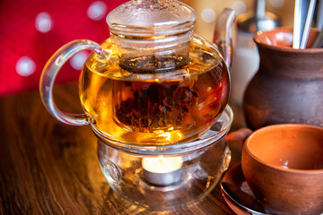 Chinese teapot with tea, on a burning support from glass