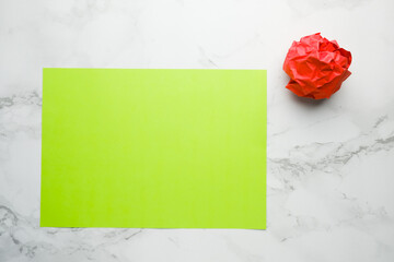 A picture of copyspace green paper with red crumpled paper on marble table. Motivation and start new life concept.
