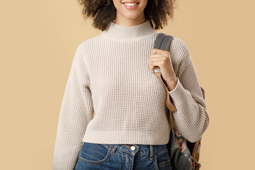 Cheerful millennial african american lady in sweater and glasses with backpack