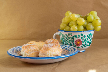 Still life with some traditional Spanish cakes and grapes presented in traditional hand-painted ceramic.