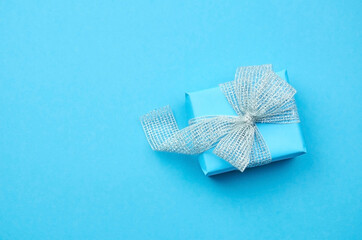 Blue gift box with silver ribbon with a bow