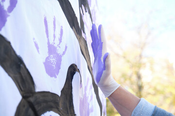 A hand painted purple participating in the International Day for the Elimination of Violence...
