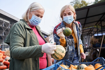 Daughter showing pumpkin to her lovely mother