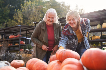 Mom and daughter considerings big pumpkin