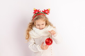 baby girl holding a red Christmas ball on a white isolated background, space for text