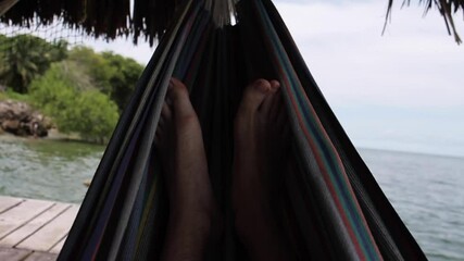 Man Lying in Swing on Beach POV  in Cartagena Colombia - Powered by Adobe