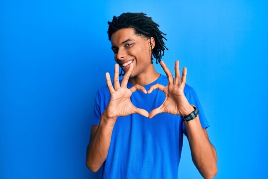 Young african american man wearing casual clothes smiling in love doing heart symbol shape with hands. romantic concept.