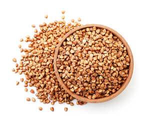 Buckwheat brown raw in a wooden plate on a white background, isolated. Top view