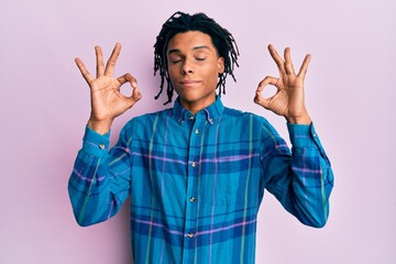 Young african american man wearing casual clothes relax and smiling with eyes closed doing meditation gesture with fingers. yoga concept.