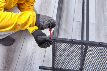Mounting of metal frame of furniture from flat pack with screwdriver.