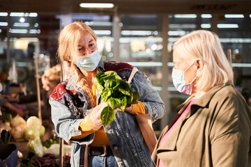 Woman showing a bunch of basil to her mother