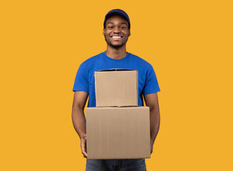 Black delivery man holding pile of boxes