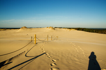Krajobraz pustynny błękitne niebo i ruchome piaski na tle błękitnego nieba z cieniem sylwetki...