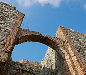 Un arco in mattoni pieni rossi di un vecchio castello in rovina 