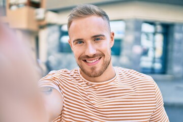 Young irish man smiling happy making selfie by the camera at street of city.