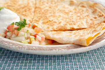 A closeup view of a plate of cheese quesadilla.