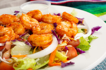 A view of a spicy shrimp salad, in a restaurant or kitchen setting.