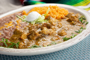 A view of a plate of chile verde, in a restaurant or kitchen setting.