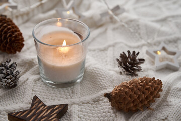 Fototapeta na wymiar Burning candle and christmas decorations. Winter cozy home and hygge concept