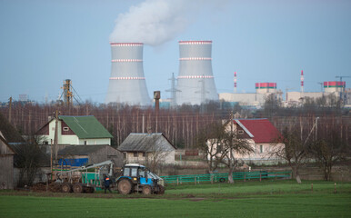 tractor work against the backdrop of a nuclear power plant.