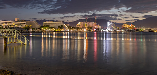 Night on the central public beach in Eilat - famous tourist resort and recreational city in Israel, concept of happy vacation and healthy resting


