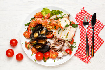 Assorted seafood on a plate on a white wooden table.