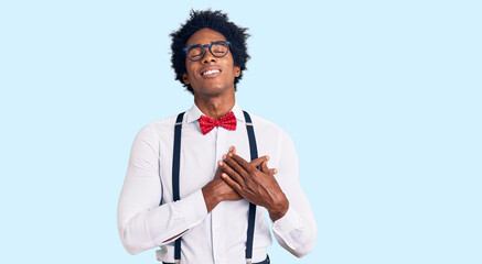 Handsome african american man with afro hair wearing hipster elegant look smiling with hands on...
