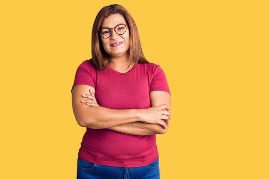 Middle age latin woman wearing casual clothes and glasses happy face smiling with crossed arms looking at the camera. positive person.