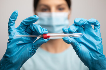 Medical healthcare nurse holding Coronavirus COVID-19 swab test kit, PPE protective mask and...