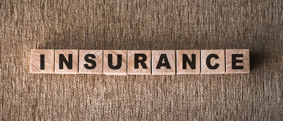 INSURANCE word written on wooden blocks on a brown background.