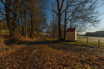 Chapel near path to Rybnik village with color sunrise light and frosty air