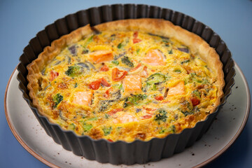 Traditional salmon quiche with broccoli and vegetables