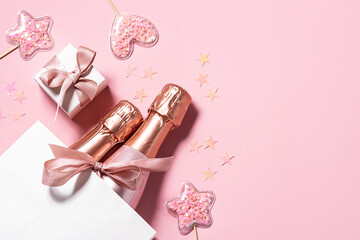 Creative festive composition with two bottles of Champagne or luxury wine in white paper bag, gift...