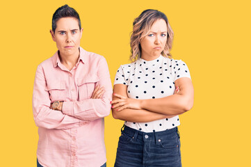 Couple of women wearing casual clothes skeptic and nervous, disapproving expression on face with...