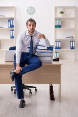 Young businessman unhappy with excessive work in the office