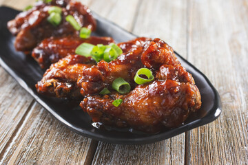 A view of a plate glazed chicken wings.