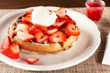 A view of a strawberry Belgian waffle on a plate.