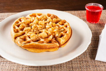 Obraz na płótnie Canvas A view of a cinnamon apple Belgian style waffle on a plate.