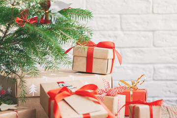 Many Handmade zero waste Christmas gift boxes under fir tree on floor in room