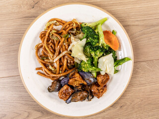 A vegetarian Chinese plate of eggplant, tofu, steamed vegetables and noodles